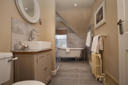 a bathroom with a sink and a bath tub at Mill End Hotel in Chagford