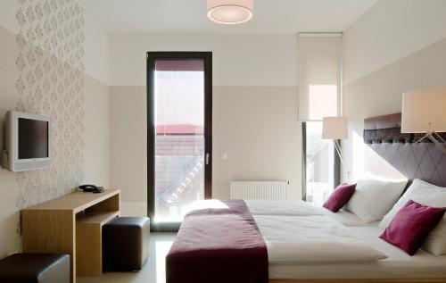 ein Hotelzimmer mit einem Bett und einem TV in der Unterkunft Hotel Zur Schonenburg in Schönberg am Kamp