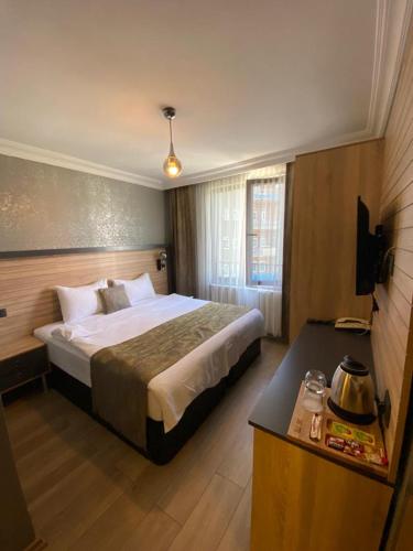 a hotel room with a bed and a table at Çağ Otel in Erzurum