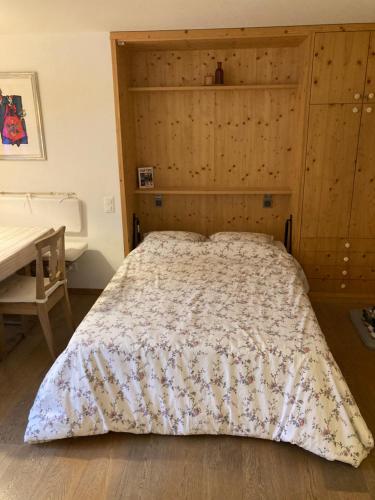 una camera da letto con un letto grande con testiera in legno di La Gemma a Celerina