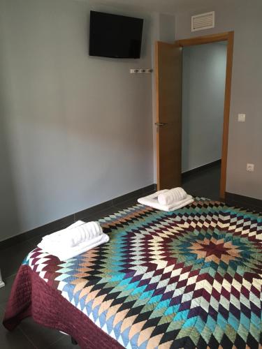 a bedroom with a bed with a colorful quilt on it at Apartamento Turístico Obispo36 en Orihuela ciudad in Orihuela