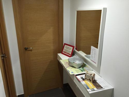 a bathroom with a wooden door and a mirror at Apartamento Turístico Obispo36 en Orihuela ciudad in Orihuela