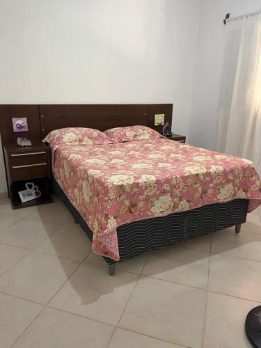 アウト・パライーゾ・デ・ゴイアスにあるConexão Hostelのベッドルーム1室(花の咲く毛布付きのベッド1台付)
