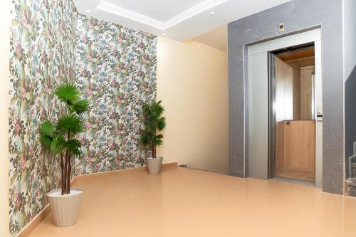 a hallway with two potted plants on the wall at Residence Issrae 1 in Nador
