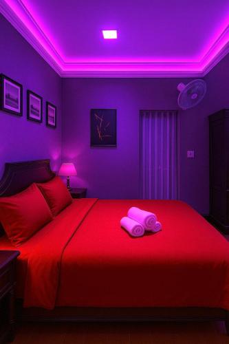 a purple room with a bed with two towels on it at TTR Skypool View Hotel in Da Lat
