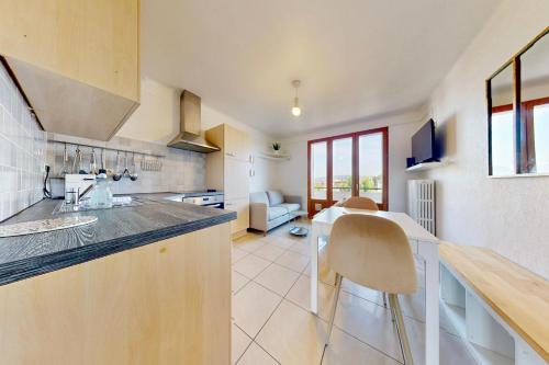 une cuisine avec un comptoir, une table et des chaises dans l'établissement 3 Quater Avenue de Chevesnes, à Annecy