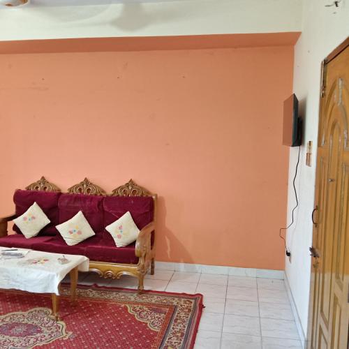 a living room with a red couch with pillows at private apartment in hill view tower in Sylhet
