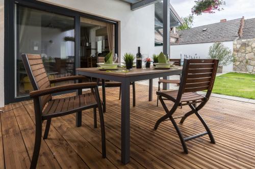 a wooden table and two chairs on a deck at Ferienhaus Burgenland 2 in Mönchhof