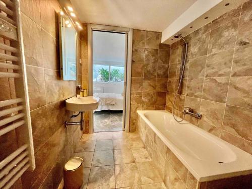 une salle de bain avec une baignoire et un lavabo dans l'établissement Villa MARGARITTA 4km Cannes centre et plages, au Cannet