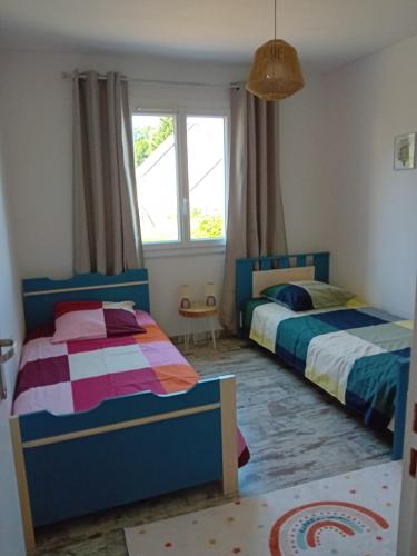 a bedroom with two beds and a window at Spacieuse maison "Des 3 filles" pour 6 personnes in Ally