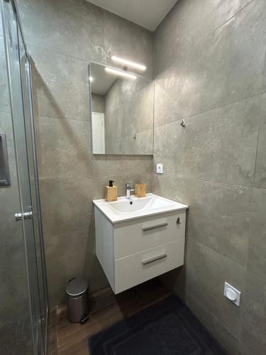 a bathroom with a white sink and a mirror at Domaine Baccia Donna Proche Nice, Climatisation, Jacuzzi chauffé, Pétanque & Parking gratuit in La Trinité