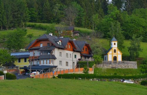 a group of houses on a hill with a church at Ferienwohnungen Perhofer in Birkfeld