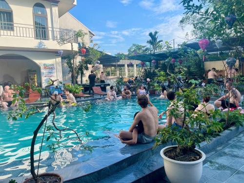 a group of people sitting in a swimming pool at Tuan Ngoc Hotel in Ninh Binh