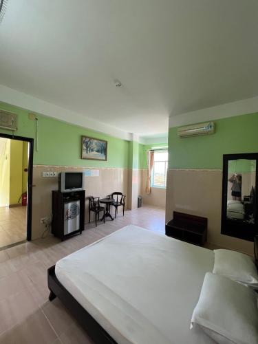 a bedroom with a large bed and a living room at Khách sạn phi long 2 in Ấp Phú Thọ