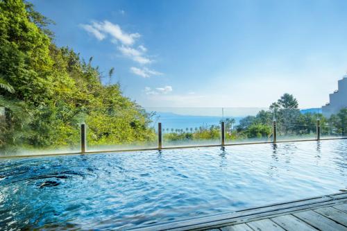 a swimming pool with a view of the water at Ooedo Onsen Monogatari Hotel Ranpu in Hirado