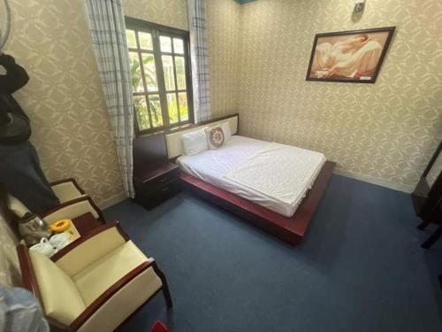 a small bedroom with a bed and a chair at Khách sạn phi long 2 in Ấp Phú Thọ