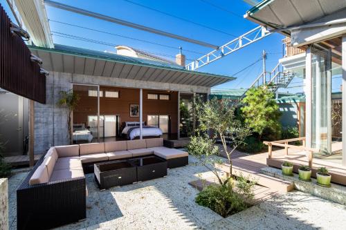 a backyard patio with a couch and a bed at 葉山Yashiro - 小型犬1匹まで一緒に泊まれる一棟貸し別荘 in Hayama