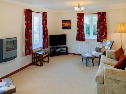 ein Wohnzimmer mit Sofa und Fernseher in der Unterkunft Friarystone Cottage in Bamburgh
