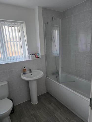 a bathroom with a sink and a shower and a toilet at Alyc-home in Peterborough
