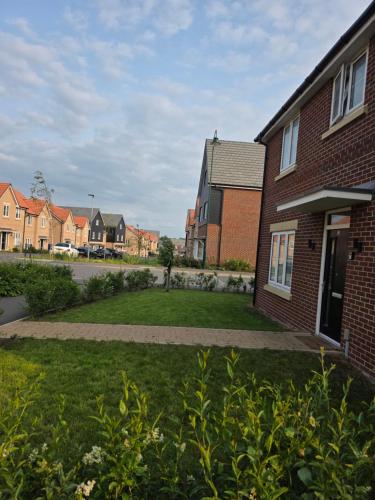 a brick house with a lawn in front of it at Alyc-home in Peterborough