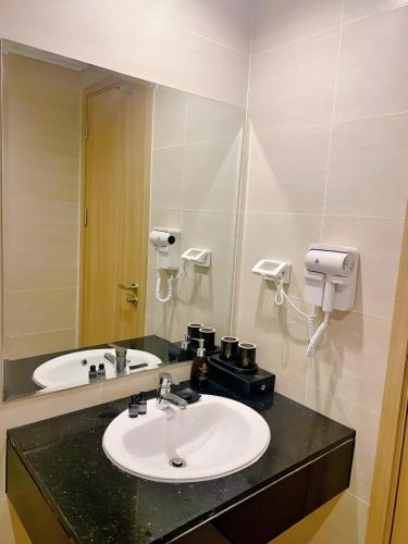 a bathroom with a sink and a mirror at Vũ Gia Phú Quốc Hotel in Phu Quoc