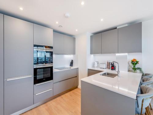 a kitchen with white cabinets and a white counter top at Sound Of The Sea in Ramsgate