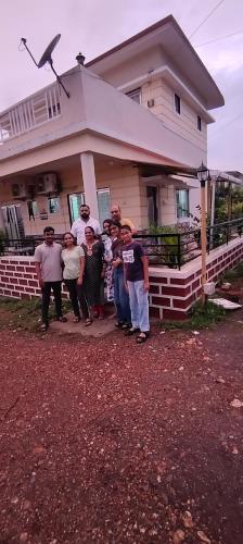 a group of people standing in front of a house at Siddhi Sea View Bungalow Ganpatipule for Family in Ratnagiri
