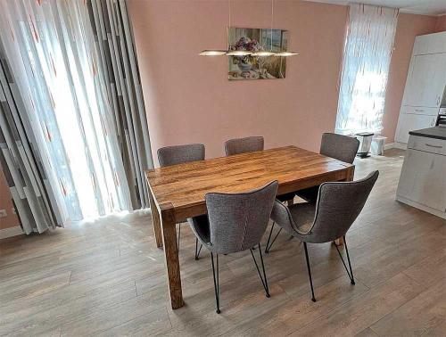 a wooden table and chairs in a room at Ferienhaus Meiereikoppel 11 in Bannesdorf