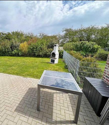 a glass table sitting on a patio with a bench at Ferienhaus Meiereikoppel 11 in Bannesdorf