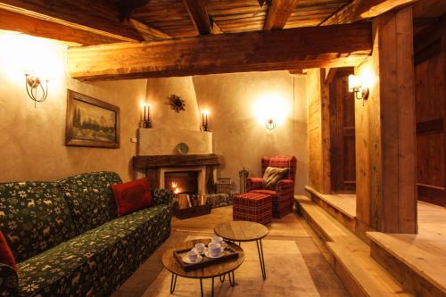 a living room with a couch and a fireplace at Au Coeur Des Neiges Resort SPA & FREE E-BIKE in Courmayeur