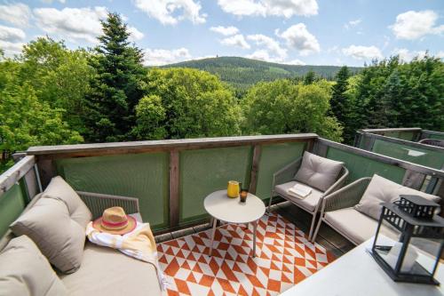 a balcony with a table and chairs and a view at Erzgebirge Suite Gipfelgrün in Kurort Oberwiesenthal