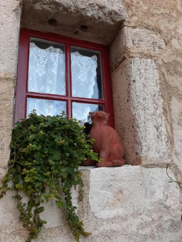a statue of a cat sitting in a window at La Belle Epoque in La Celle-sous-Gouzon