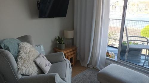 a living room with a chair and a window at 2 Bedroom Harbour Apartment in Porthmadog
