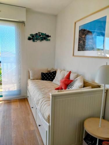 - un canapé dans une chambre avec fenêtre dans l'établissement Charmant Appartement proche mer et centre, calme, 4 pers, à Cabourg