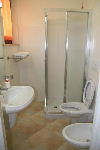 a bathroom with a shower and a toilet and a sink at Residence Stella Del Gran Sasso in Colledara