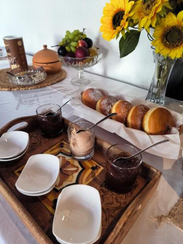 a table with a tray of bread and plates and flowers at Omir Bed & Breakfast in Pula