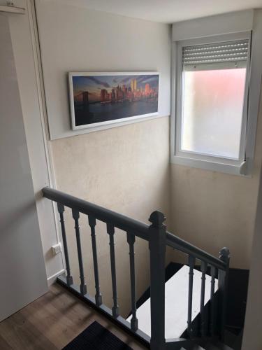 un escalier avec une fenêtre et une photo sur le mur dans l'établissement Appt de 40m2 proche de la plage, à Berck-sur-Mer