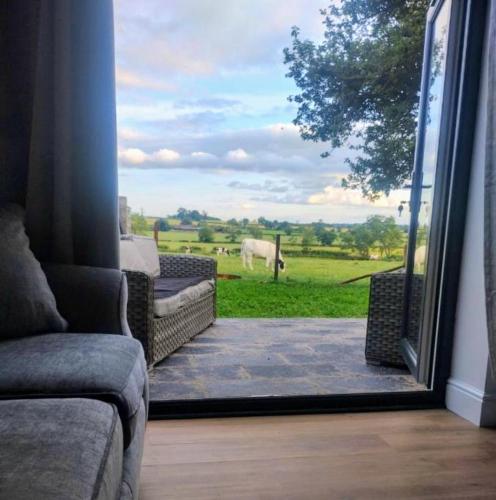 a living room with a view of a cow through a window at The Calf House in Sibbertoft