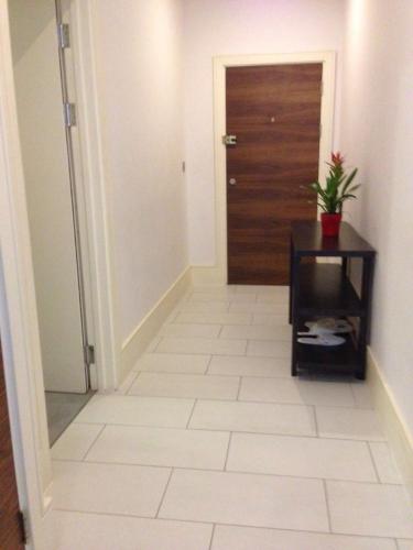 a hallway with a door and a tile floor at Hestia Travel London in London