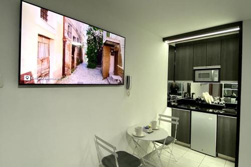 a kitchen with a table and a tv on a wall at Mini Apartment in Lima