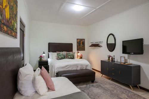 a bedroom with two beds and a tv and a couch at Leipzig Country House & Winery in Nuy