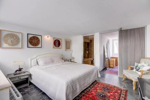 une chambre blanche avec un lit et une chaise dans l'établissement Villa MARGARITTA 4km Cannes centre et plages, au Cannet