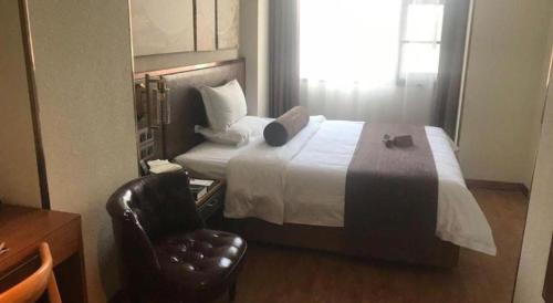 a hotel room with a bed and a chair at James Joyce Coffetel Xi'an Lingtong The Terracotta Army Huaqingchi University Town Metro Station in Xi'an
