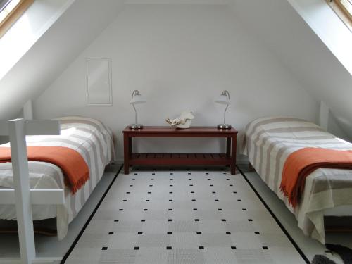 een slaapkamer op zolder met 2 bedden en een tafel bij Dyssegaard B&B in Skallerup