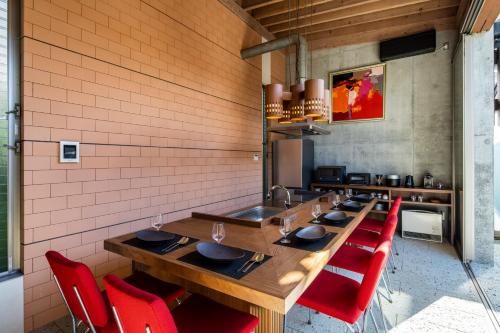 a dining room with a long table and red chairs at 葉山Yashiro - 小型犬1匹まで一緒に泊まれる一棟貸し別荘 in Hayama