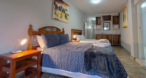 a bedroom with a bed and a table with a night stand at LookOut Ramsgate in Ramsgate