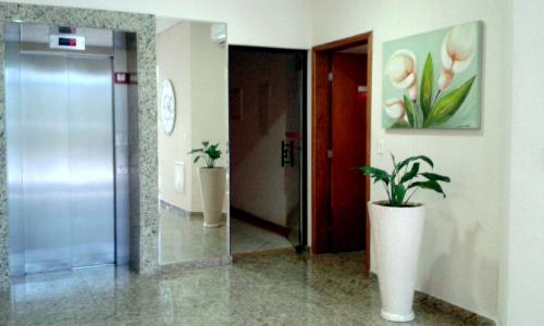 a hallway with a glass door and a potted plant at Hotel Eden in Sorocaba