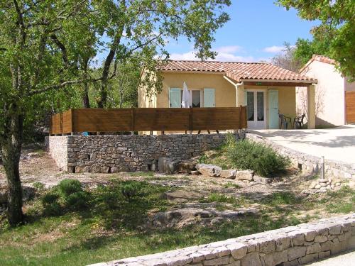 een huis met een hek en een stenen muur bij Gîtes des Campanes in Saint Alban Auriolles