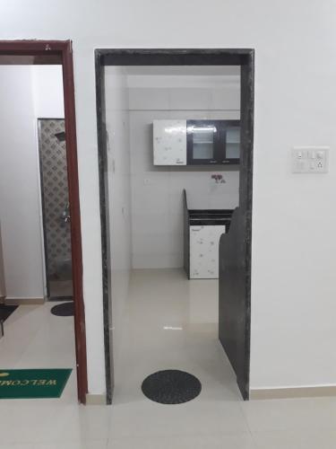 an open door into a kitchen with a microwave at Spanish villa , chinchoti in Bapane