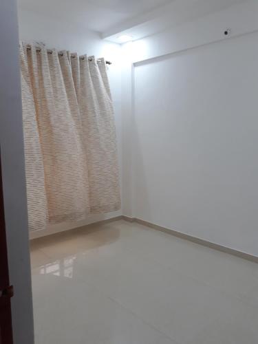 a white room with a window and a curtain at Spanish villa , chinchoti in Bapane